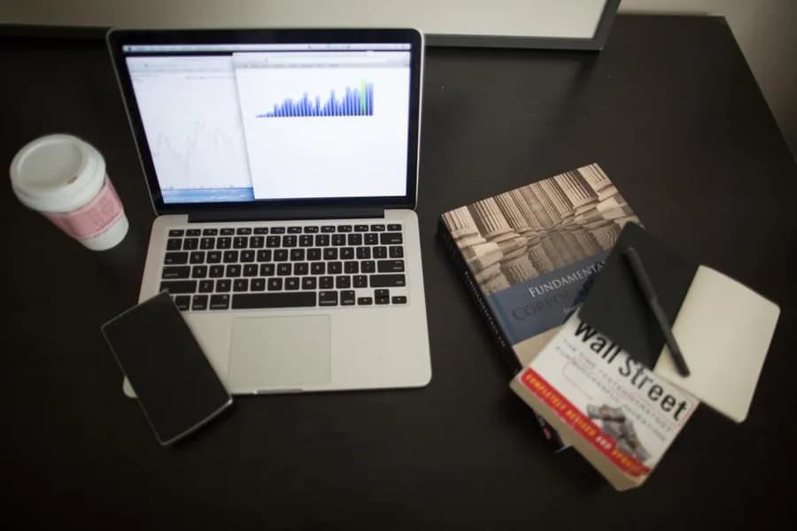 A financial newspaper open beside a laptop