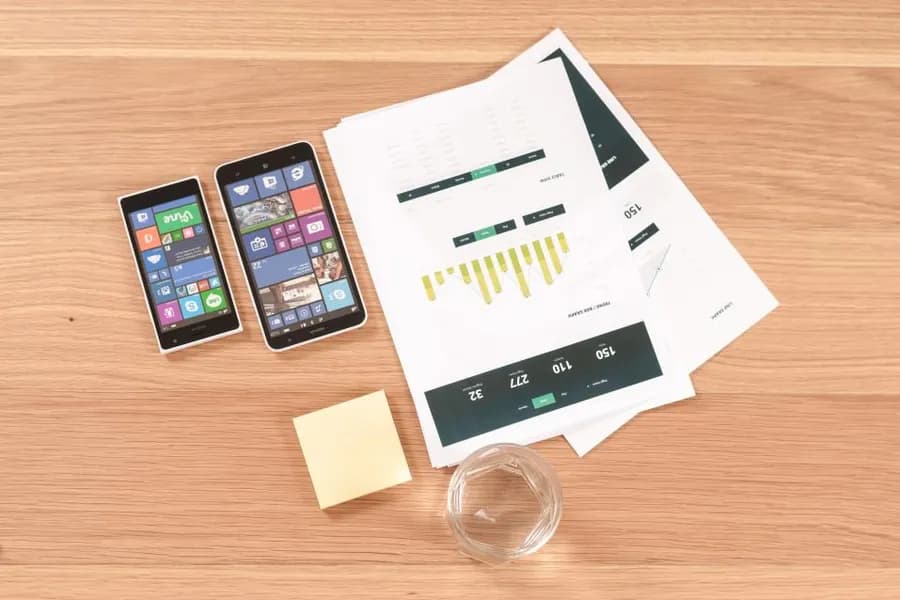 Reports, phones and handwritten notes on a desk