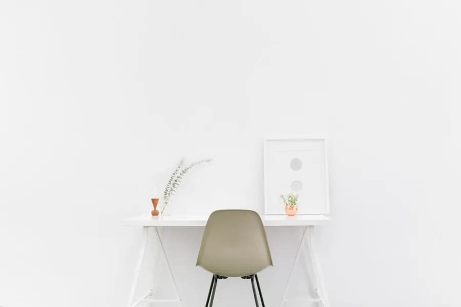 A small office desk with a chair beside a window