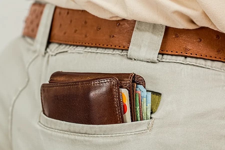 A wallet holding cards in a trouser pocket