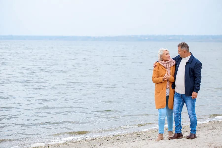 Two people walking along a waterfront