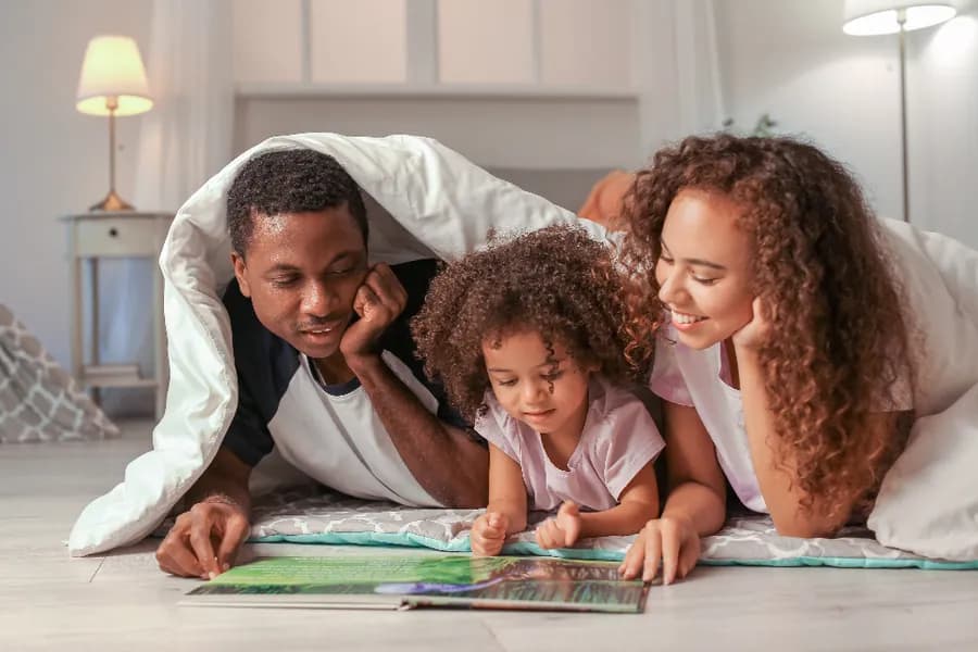 A family reading together on the floor at home