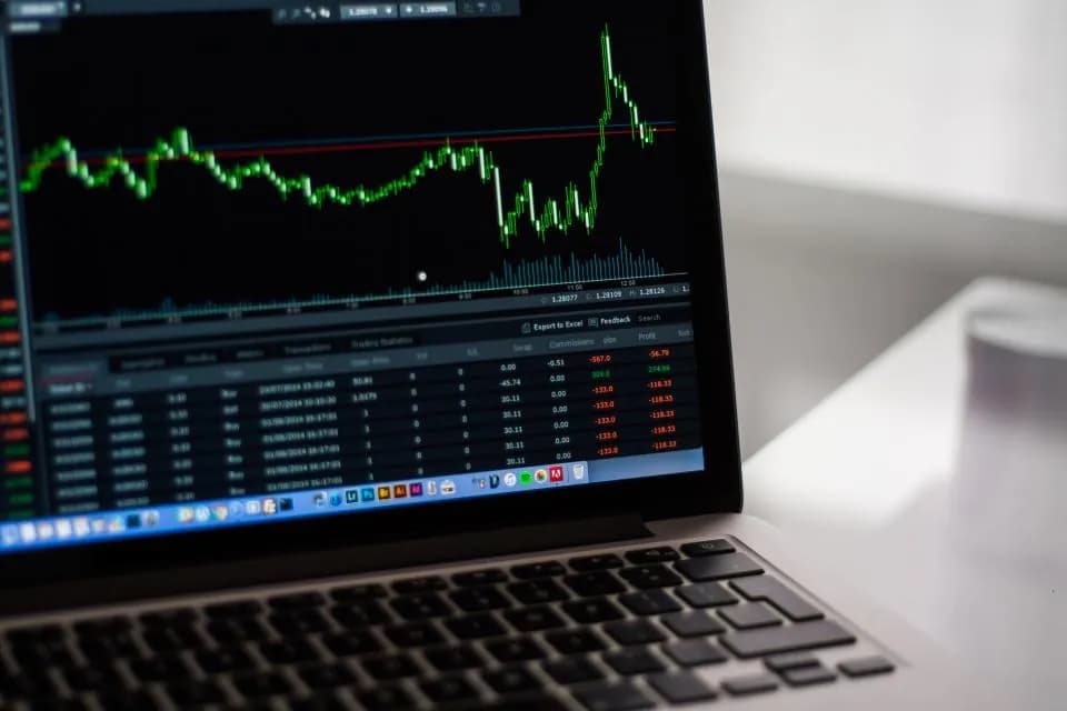 A laptop displaying a candlestick price chart