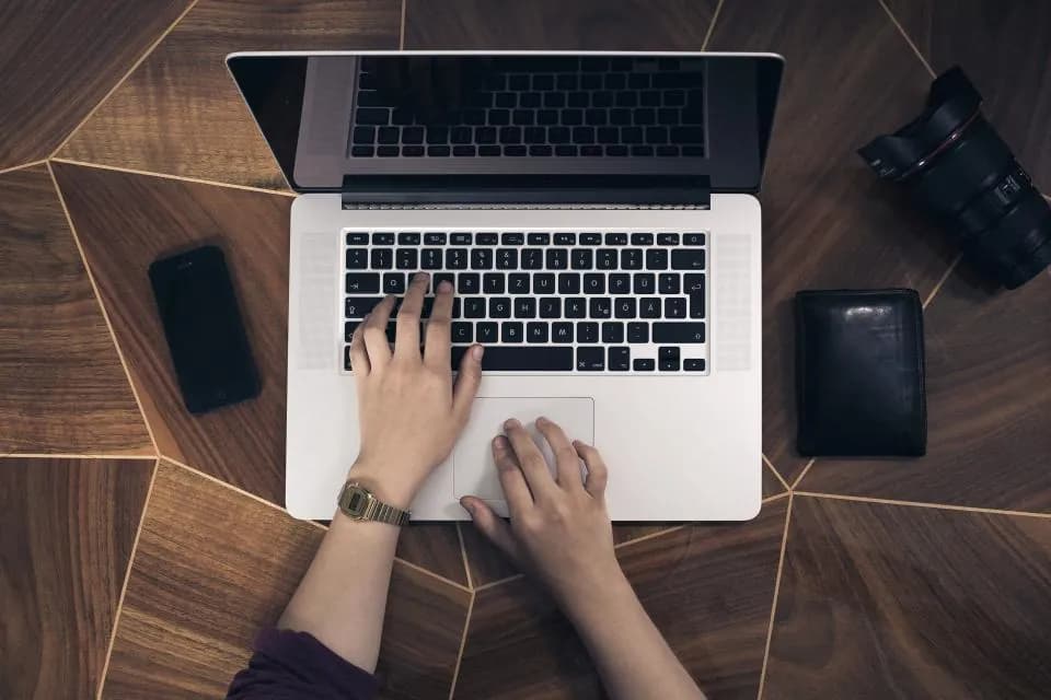 Overhead view of a person typing at a laptop