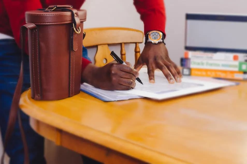 A person signing documents at a table