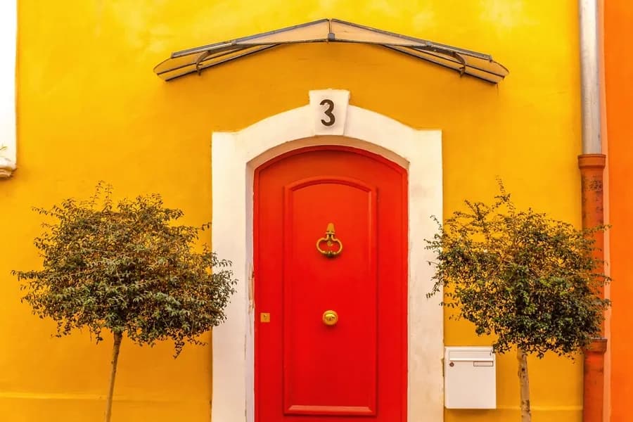 A red front door in a painted facade