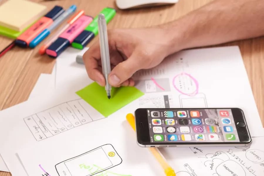 Handwritten notes and a phone on a desk