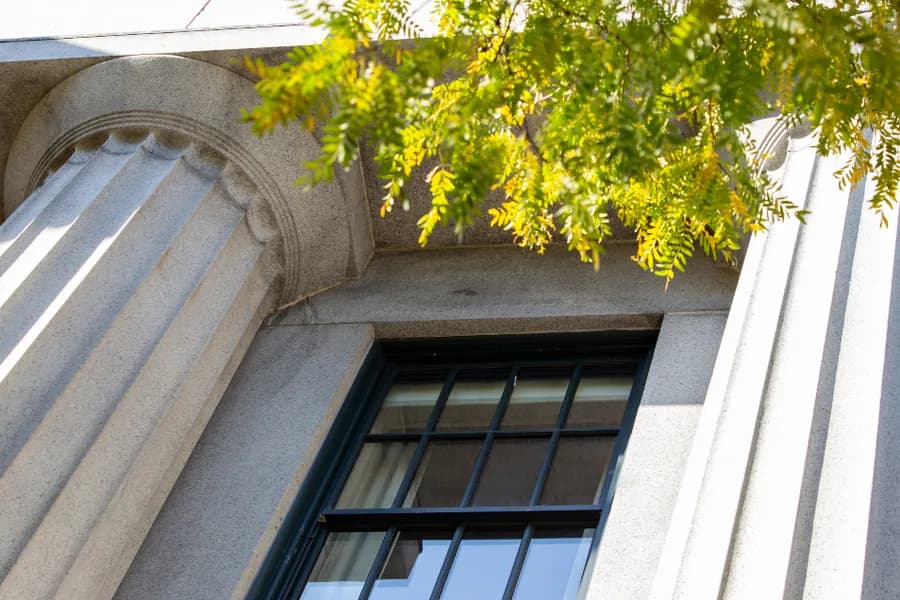 The stone facade and window of an older bank building