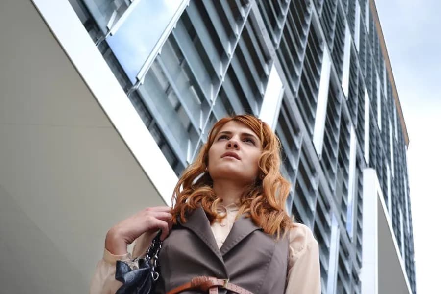 A person standing outside a modern office building