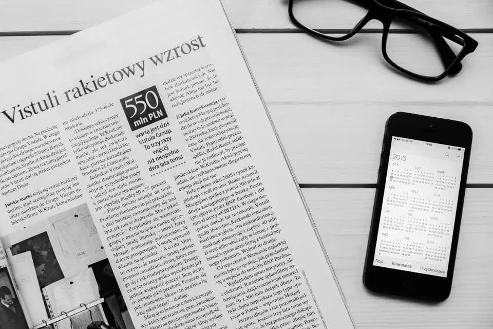 A financial newspaper beside reading glasses