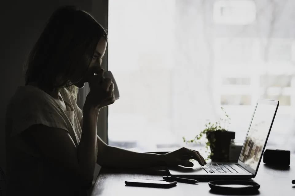 A person at a laptop photographed in black and white